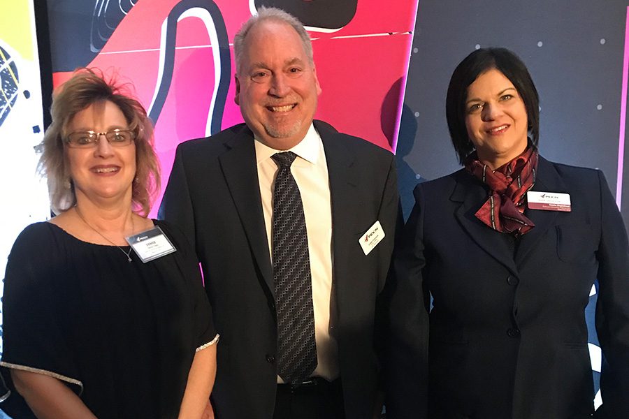 About Our Agency - Denise and Trisha Standing With a Colleague at an Awards Event